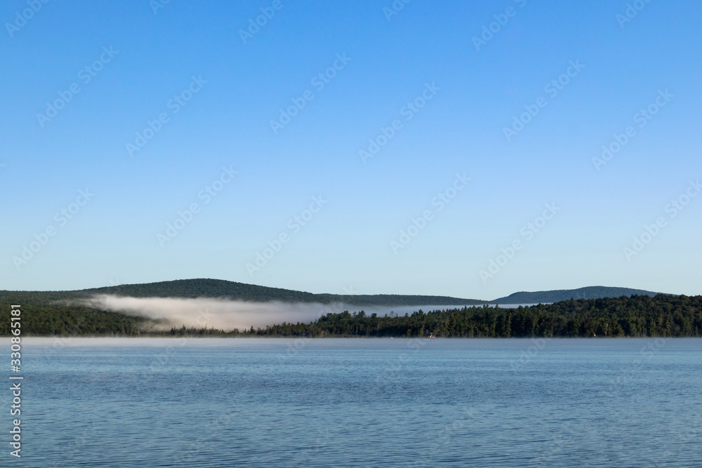 Peaceful and serene lake landscape with low-hanging clouds, Adirondacks, New York, USA