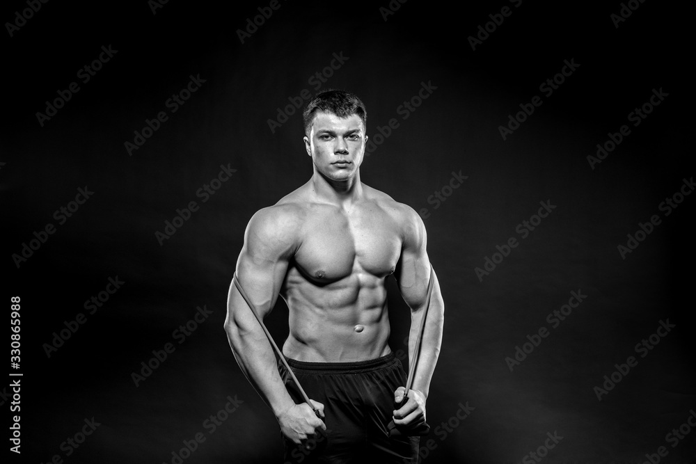 Sexy young athlete posing on a black background in the Studio. Fitness, bodybuilding, black and white Sexy young athlete posing on a black background in the Studio. Fitness, bodybuilding, black and white
