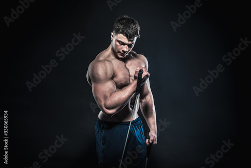 Sexy young athlete posing on a black background in the Studio. Fitness, bodybuilding © Andrii