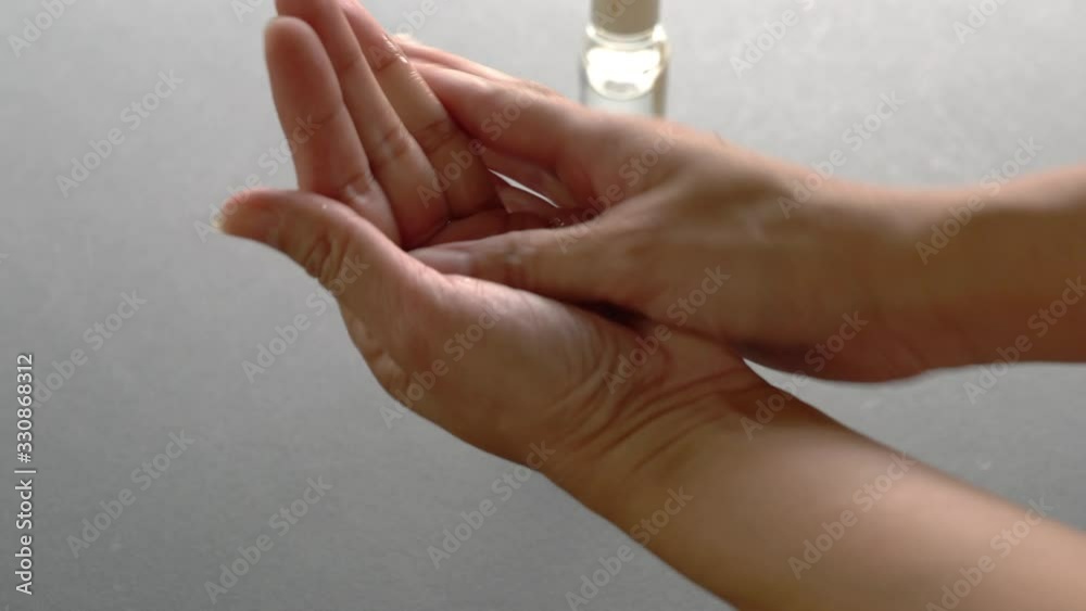 Woman uses hand sanitizer. Pour sanitizer onto her hands and rub into her hands. Closeup. Woman uses hand sanitizer. Pour sanitizer onto her hands and rub into her hands. Closeup.