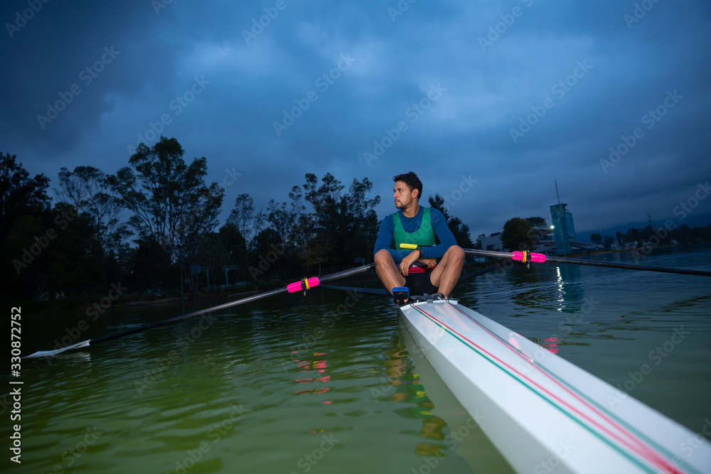 rowing man on lake posing and cloudy sky rowing man on lake posing and cloudy sky