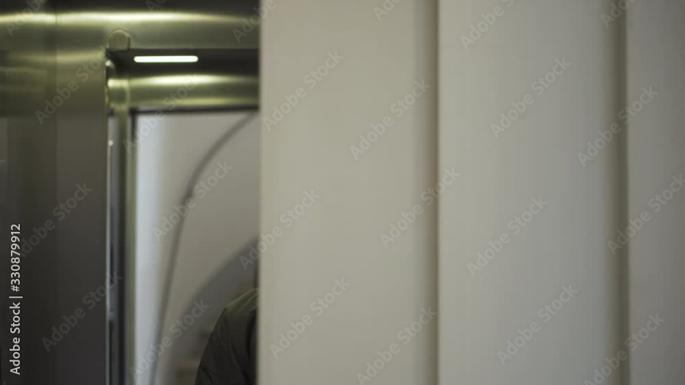Young man with black mask standing in an elevator in times of corona virus. Young man with black mask standing in an elevator in times of corona virus.