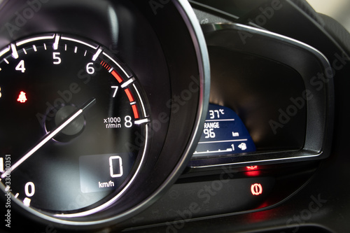 A dashboard with tachometer of car, close up. Dashboard in vehicle with indicators about speed.
