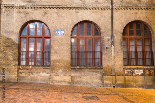 Three windows of an ancient city on a stone wall with square patterns