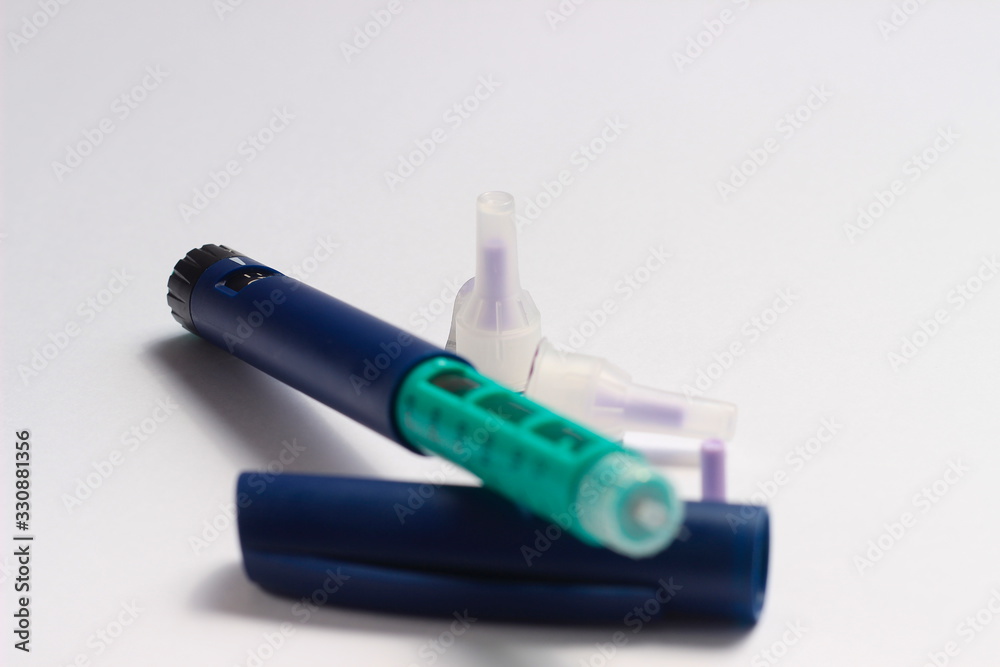 Close Up Photo, Blue and Green Insulin Pen at White Background Close Up Photo, Blue and Green Insulin Pen at White Background
