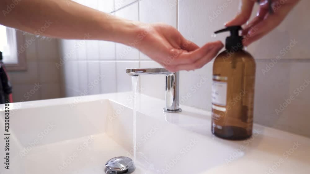 Person thoroughly washing hands with soap above a sink. Person thoroughly washing hands with soap above a sink.