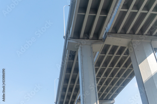 Underneath View of bridge pillars and concrete bridge of highways with the background of the sky in the day time