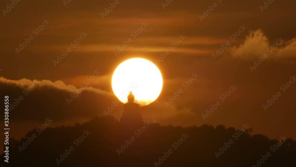 hue sunset over silhouette Phuket big buddha statue on hilltop with many big trees high mountain in the beautiful evening colourful orange twilight sky,moving cloud, attraction tourist photo spot hue sunset over silhouette Phuket big buddha statue on hilltop with many big trees high mountain in the beautiful evening colourful orange twilight sky,moving cloud, attraction tourist photo spot