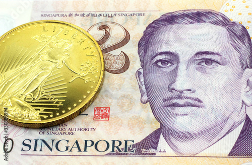 Photography A macro image of a Singapore two dollar bill with a gold coin