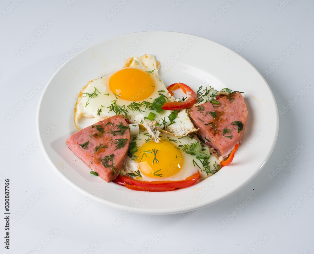 Fried sausage fried eggs on a white round plate. Side view Fried sausage fried eggs on a white round plate. Side view
