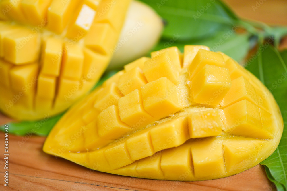 Sweet ripe mangos cut - Mango slice and mango leaves from tree tropical summer fruit concept Sweet ripe mangos cut - Mango slice and mango leaves from tree tropical summer fruit concept