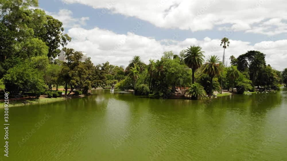 Aerial over the lake in Bosques de Palermo to reveal the skyline and the park while the drone slowly ascends. Aerial over the lake in Bosques de Palermo to reveal the skyline and the park while the drone slowly ascends.