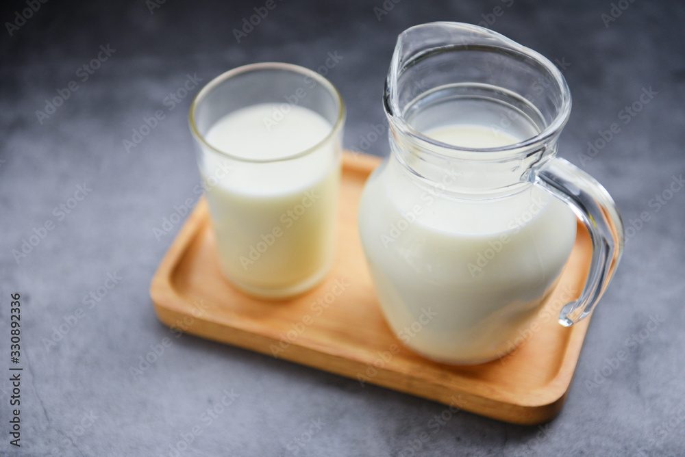 Fresh milk natural in a glass jug on wooden tray - Serving breakfast milk concept Fresh milk natural in a glass jug on wooden tray - Serving breakfast milk concept