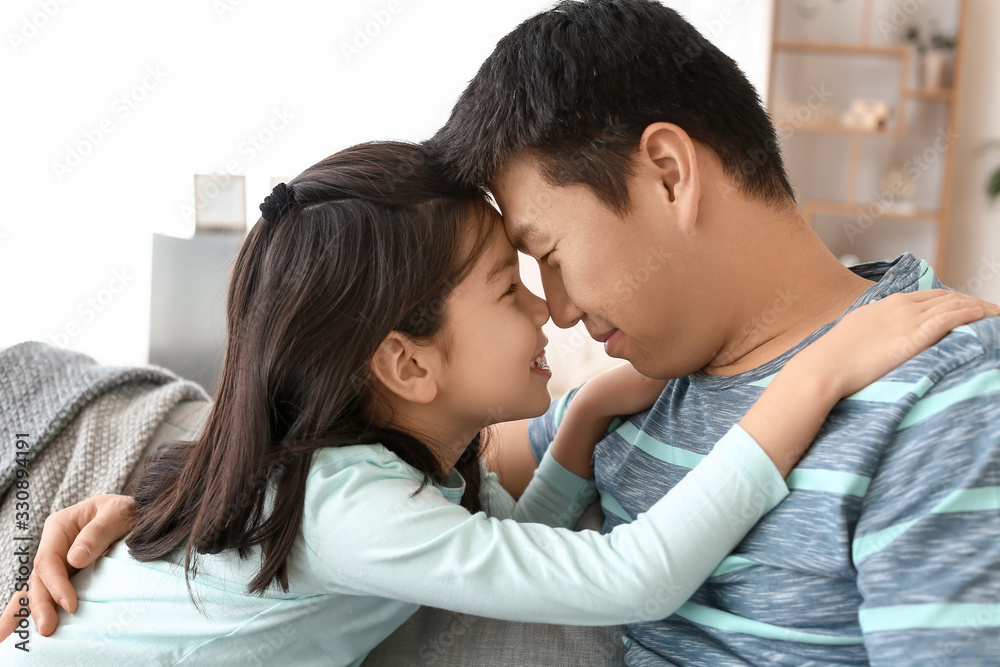 Happy Asian man and his little daughter at home Happy Asian man and his little daughter at home