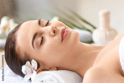 Beautiful young woman relaxing in spa salon