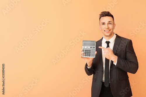 Young man with calculator o...