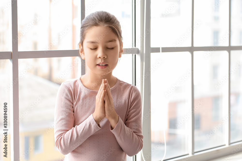 Cute little Asian girl praying at home Cute little Asian girl praying at home