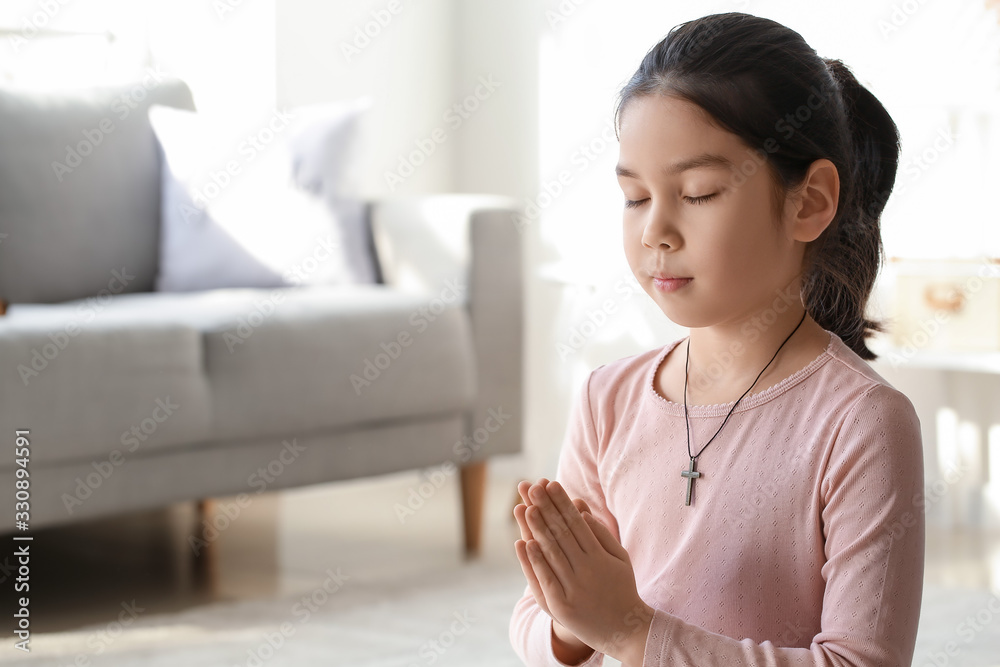 Cute little Asian girl praying at home Cute little Asian girl praying at home