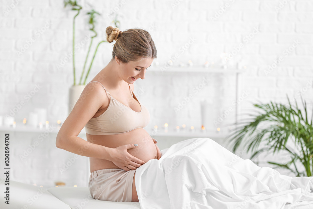 Young pregnant woman resting in spa salon