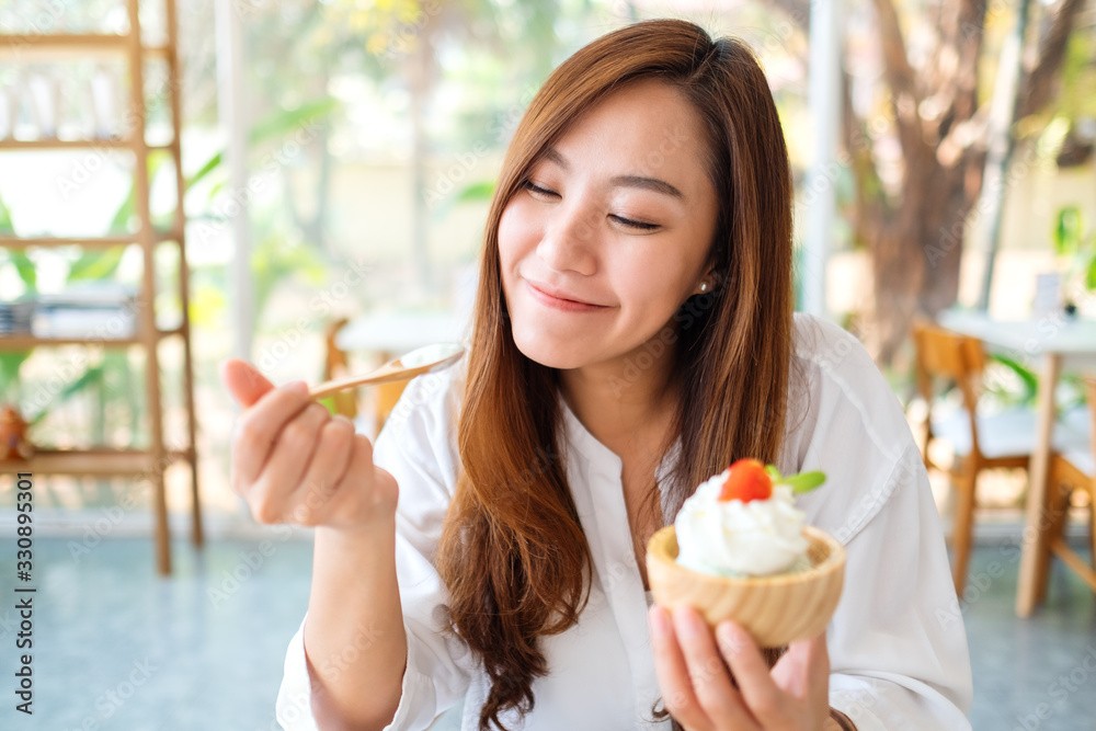 Closeup image of a beautiful asian woman enjoy eating an ice cream in restaurant Closeup image of a beautiful asian woman enjoy eating an ice cream in restaurant