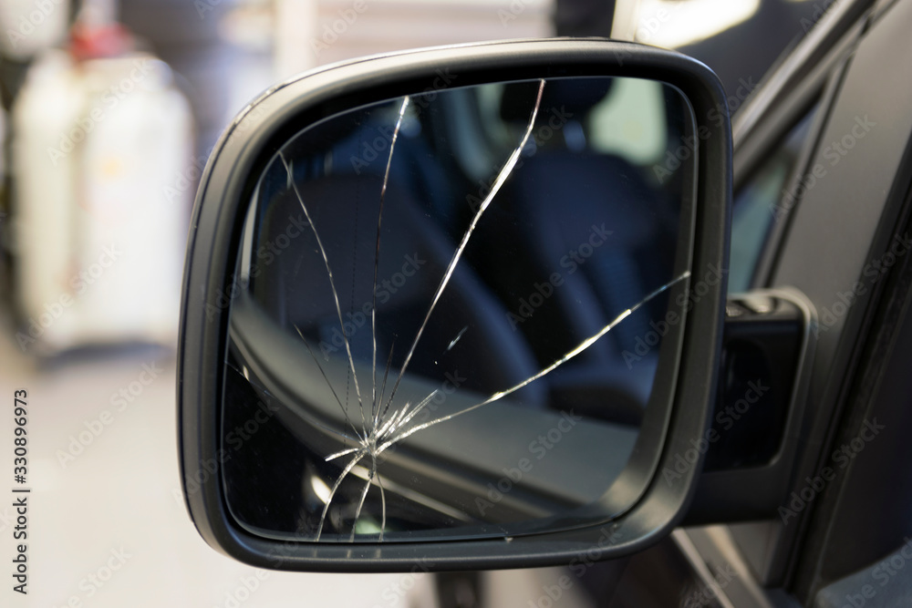 Car with a broken side mirror in a car service. Cracks in the car mirror. Insurance car body repair.