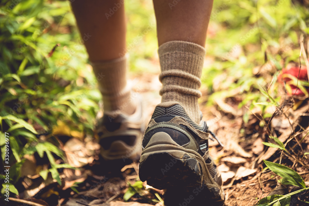 Young woman hiker legs walking on trail in spring mountains Young woman hiker legs walking on trail in spring mountains