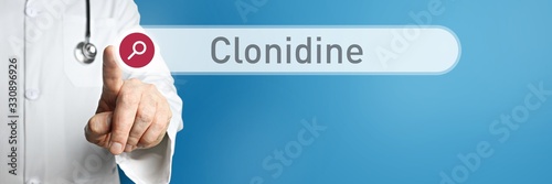 Clonidine. Doctor in smock points with his finger to a search box. The word Clonidine is in focus. Symbol for illness, health, medicine photo