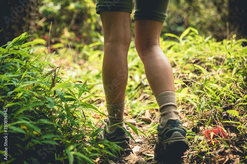 Young woman hiker legs walking on trail in spring mountains