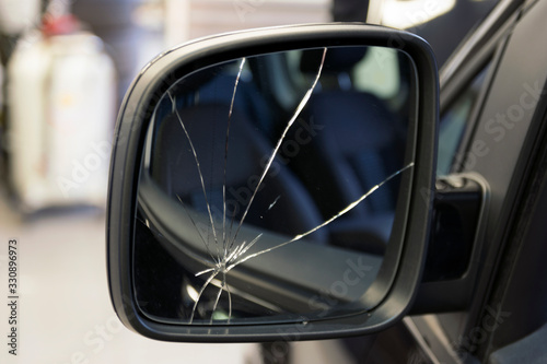 Car with a broken side mirror in a car service. Cracks in the car mirror. Insurance car body repair.