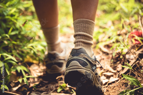 Young woman hiker legs walking on trail in spring mountains