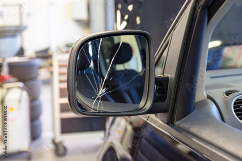 Car with a broken side mirror in a car service. Cracks in the car mirror. Insurance car body repair.