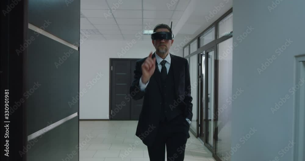 Businessman using VR glasses in office corridor Businessman using VR glasses in office corridor
