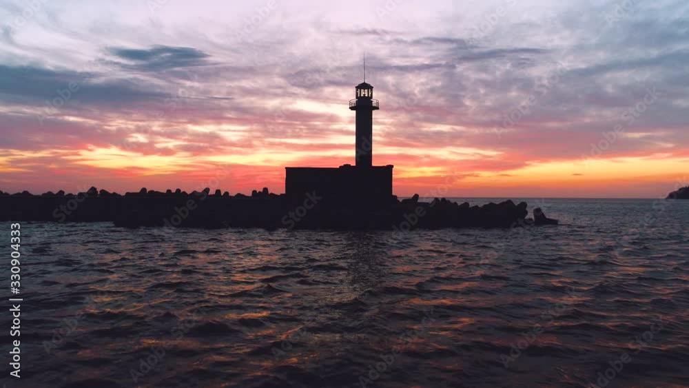 Lighthouse silhouette on the sea at sunset Lighthouse silhouette on the sea at sunset