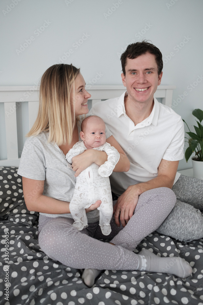 Family portrait: young mom and dad with his 2 years old son and 2 month old baby Family portrait: young mom and dad with his 2 years old son and 2 month old baby