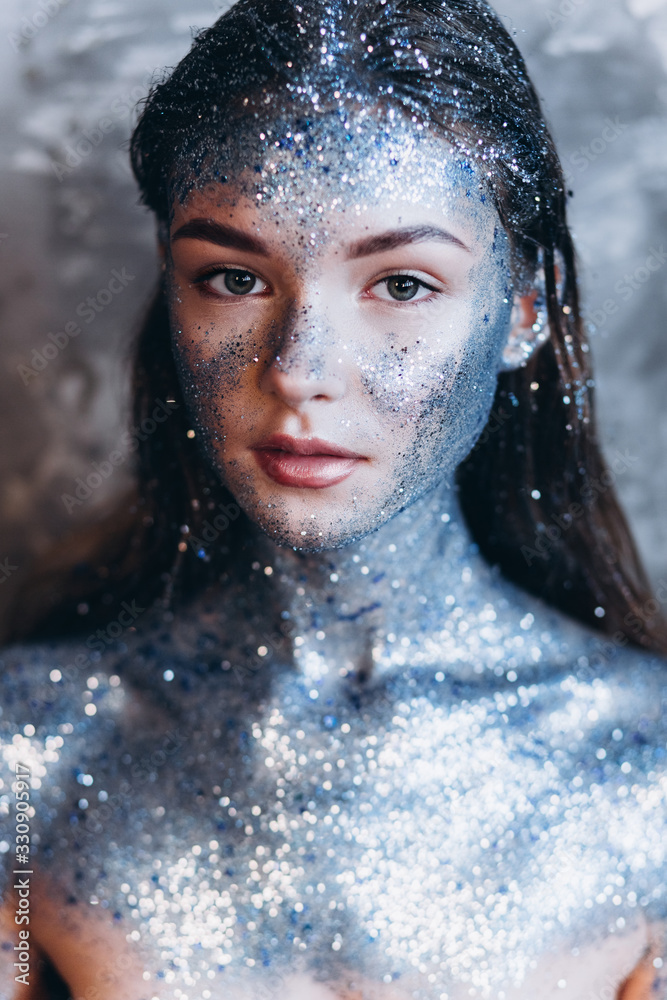 Close up portrait of young fashionable model with art make up with blue sparkles. Fashion, art, beauty concept Close up portrait of young fashionable model with art make up with blue sparkles. Fashion, art, beauty concept