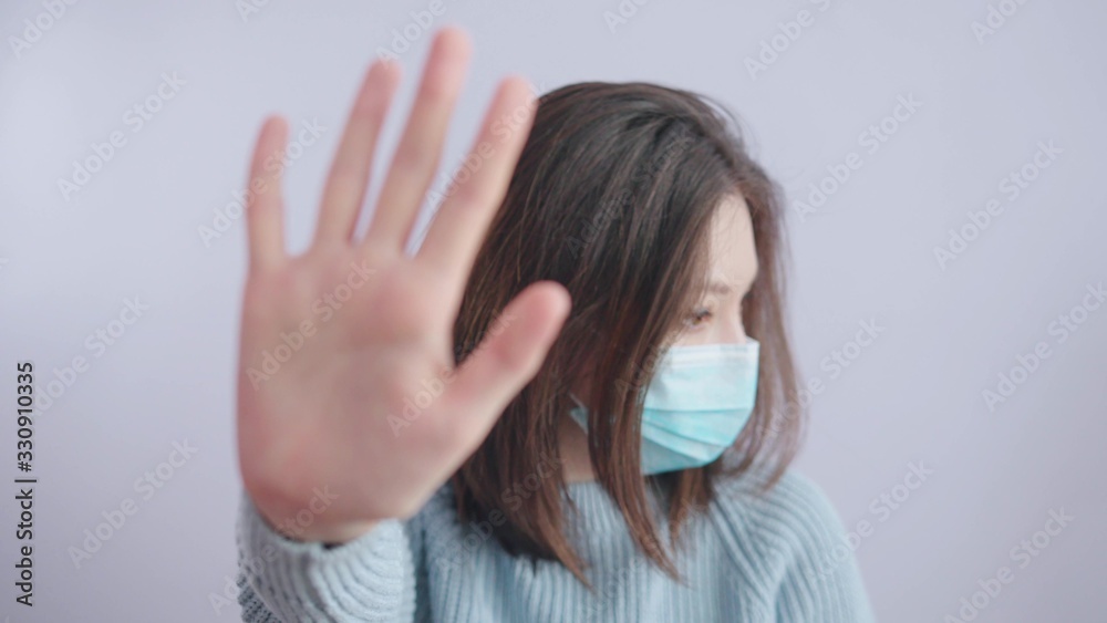 Stop the virus and epidemic diseases. Healthy woman in blue medical protective mask showing gesture stop. Health protection and prevention during flu and infectious outbreak Stop the virus and epidemic diseases. Healthy woman in blue medical protective mask showing gesture stop. Health protection and prevention during flu and infectious outbreak