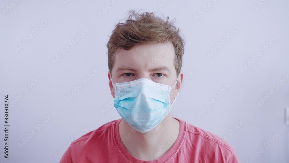 Middle-aged man puts on a protective medical mask in white studio to be safe from viruses and infections. Man with medical mask. Coronavirus 2019-ncov covid-19 concept. Middle-aged man puts on a protective medical mask in white studio to be safe from viruses and infections. Man with medical mask. Coronavirus 2019-ncov covid-19 concept.