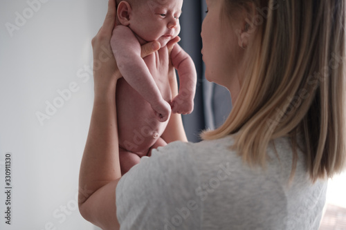 Pretty woman holding a newborn baby in her arms.