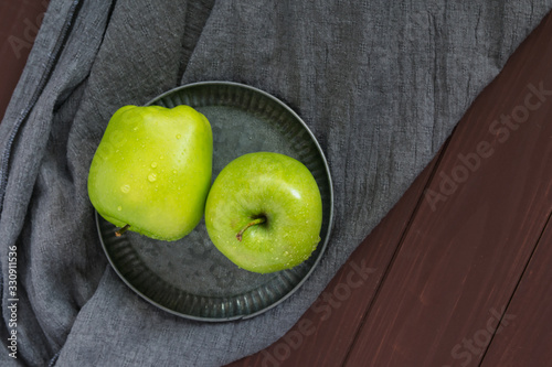 Two green apples on a gray background. Greeting card, place for your text. A symbol of a healthy lifestyle