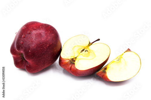 Red organic apple, half and quarter apple with water drops isolated on a white background.