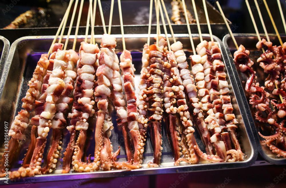 Octopus on wooden sticks for grilling.