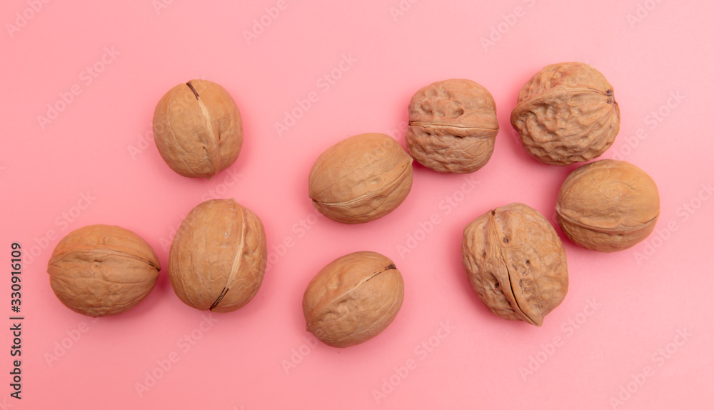 Walnuts on a pink background. Walnuts on a pink background.