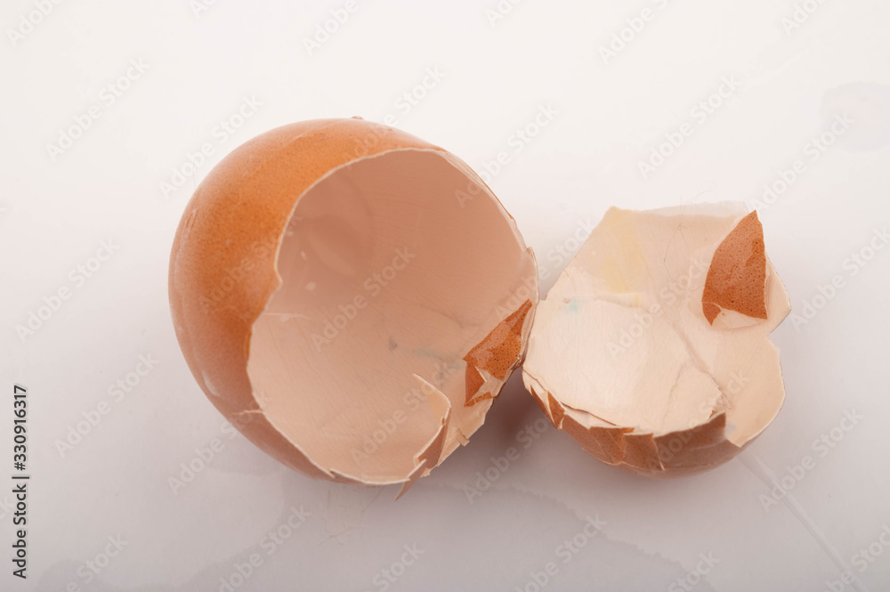 The shell of a broken chicken egg on a white background. Close up. The shell of a broken chicken egg on a white background. Close up.