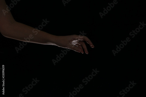 male hand in the dark. dark key, light palm illumination