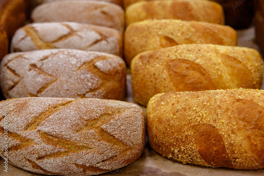 loaves of bread on a shelf or display case in a store loaves of bread on a shelf or display case in a store