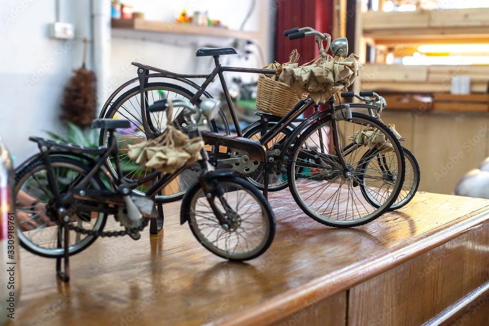 Toys metal classic bicycles on wooden table, selective focus