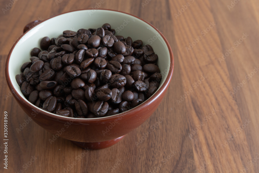 Dark roasted coffee beans in a cup. Dark roasted coffee beans in a cup.