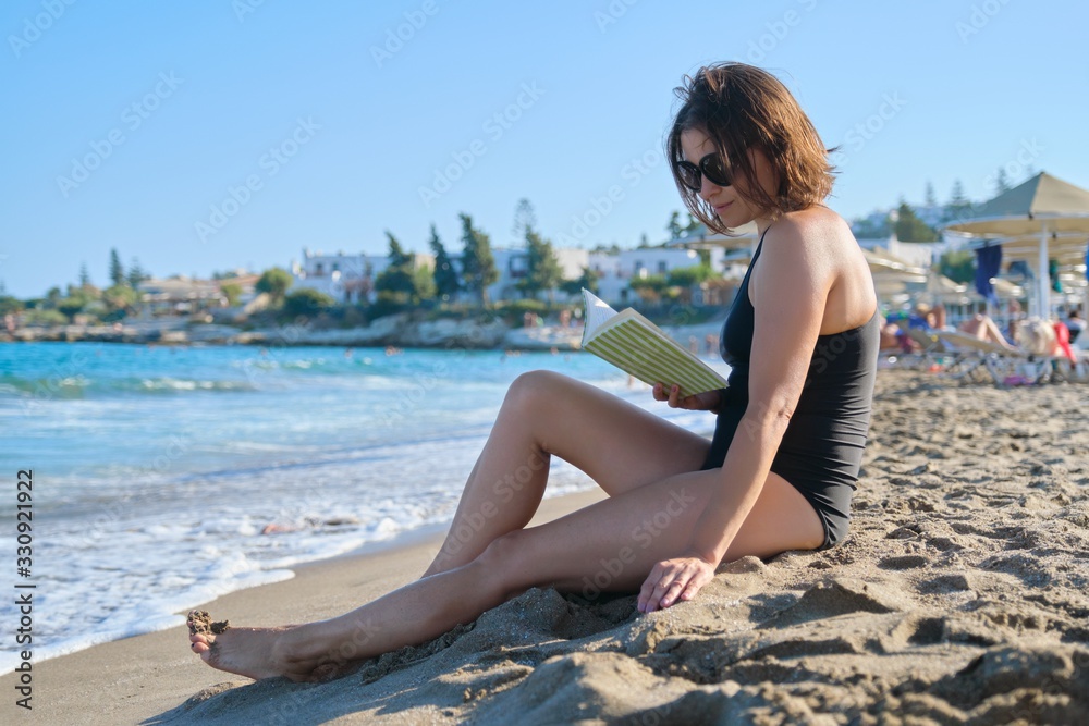 Beautiful woman 40 years old relaxing on sandy beach