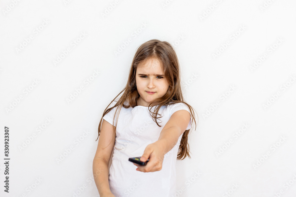 a girl, a teenager with a remote control from the TV, switches channels, search for a cartoon, is not happy, a ban on viewing, children and adults, TV and the Internet, entertainment a girl, a teenager with a remote control from the TV, switches channels, search for a cartoon, is not happy, a ban on viewing, children and adults, TV and the Internet, entertainment