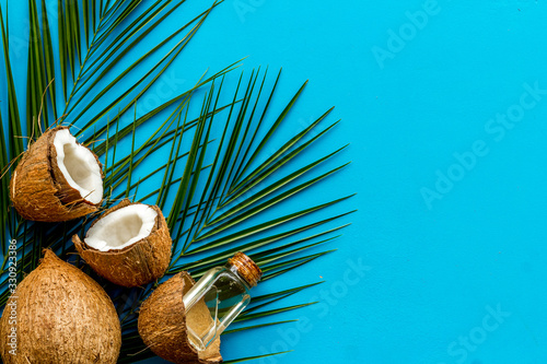 Coconut background with oil on blue background top-down copy space